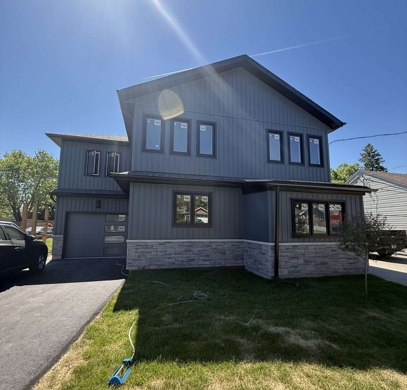 Modern grey and stone two-storey custom home built by Malamar Construction