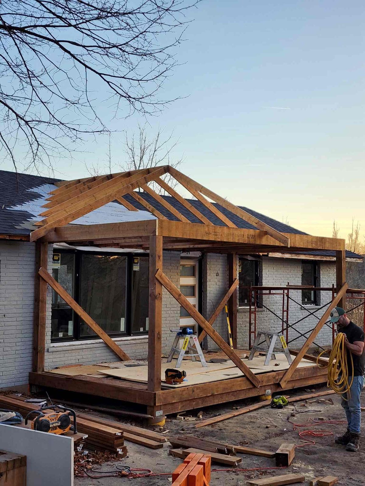 Timber-frame addition under construction at sunset