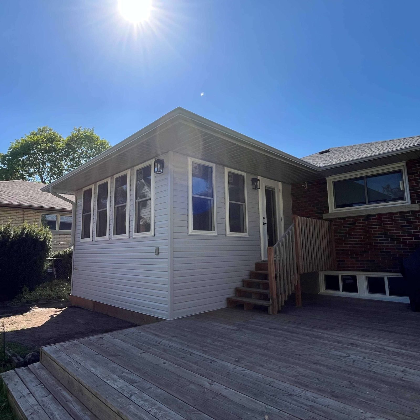 Finished modern home addition with deck and dark trim